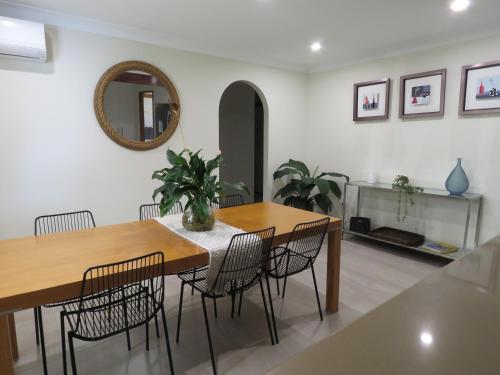 a dining room with two tables and chairs and a mirror at Waterfront house in Currumbin in Gold Coast