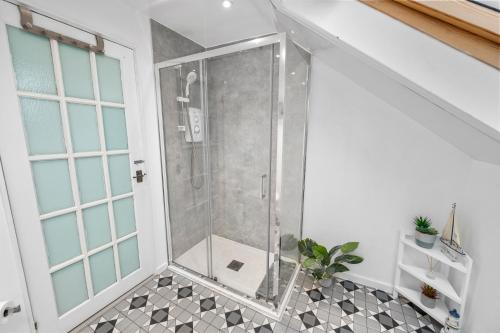 a shower with a glass door in a bathroom at Beautiful 2BR Apartment with McCaigs Tower views in Oban