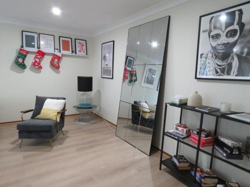 a living room with a chair and a mirror at Waterfront house in Currumbin in Gold Coast