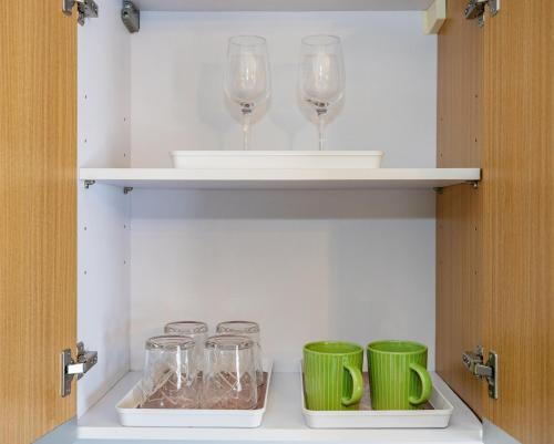 a cabinet with wine glasses and bowls on it at 617A Condotel Near Airport &Mall with Pool,Gym,Netflix in Mactan Cebu International