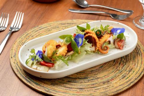 a plate of food with shrimp and vegetables on a table at Jetwing Lagoon Wellness, A Luxury Reserve - Adults Only in Negombo