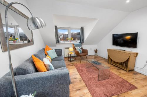 a living room with a blue couch and a tv at Beautiful 2BR Apartment with McCaigs Tower views in Oban