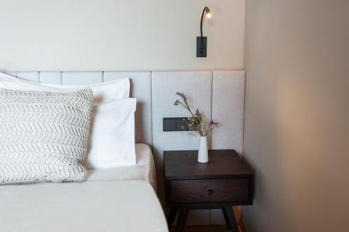 a bedroom with a bed with a vase on a table at Avidea - Adults Only in Lagundo