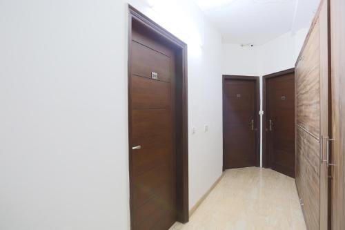 a hallway with two wooden doors in a room at Super Hotel O Mominpur Guest House in Kolkata