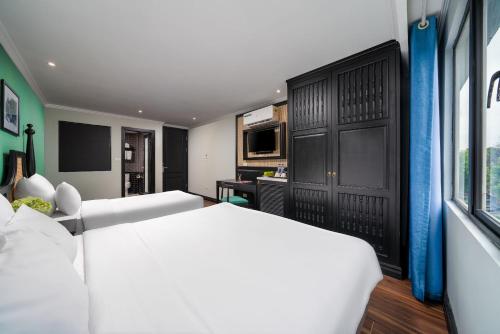 a hotel room with two beds and a television at Hanoi Ancient Paradise Hotel in Hanoi