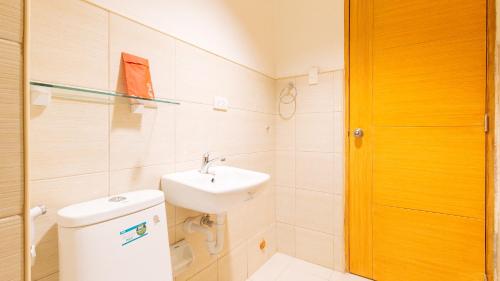 a bathroom with a toilet and a sink at RedDoorz Plus at Alpina Heights Paranaque in Manila