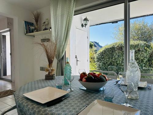 キブロンにあるAgréable 3 pièces, parking, piscine chaufféeのダイニングルームテーブル(フルーツボウル付)