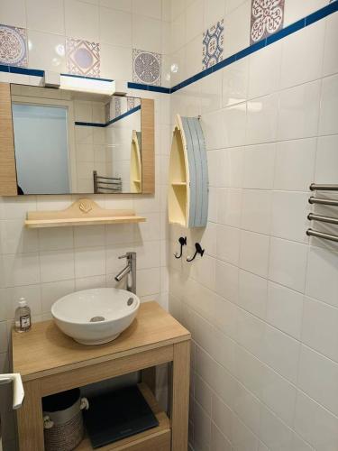 une salle de bain avec un lavabo et un miroir dans l'établissement Agréable 3 pièces, parking, piscine chauffée, à Quiberon