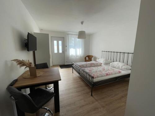a bedroom with a bed and a table and a desk at Gästezimmer im Weingut Kissel in Gundheim