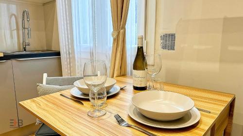 - une table en bois avec des verres et une bouteille de vin dans l'établissement Le Petit Saint Barth, à Nice