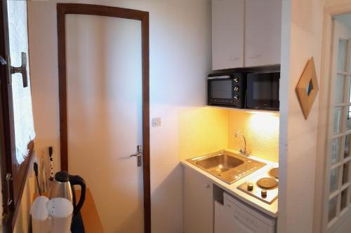 une petite cuisine avec un évier et un micro-ondes dans l'établissement Appartement Saint Pierre la Mer 6 personnes, vue sur la mer, piscine, parking, tennis M330, à Saint Pierre La Mer