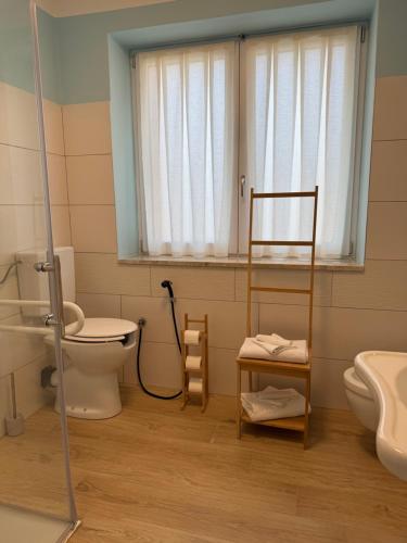 a bathroom with a toilet and a sink and a window at Albergo La Padana in Montebello Vicentino