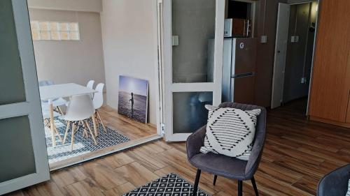 a room with a chair and a table and a mirror at Ons Strandhuisie E19 in Pearly Beach in Pearly Beach