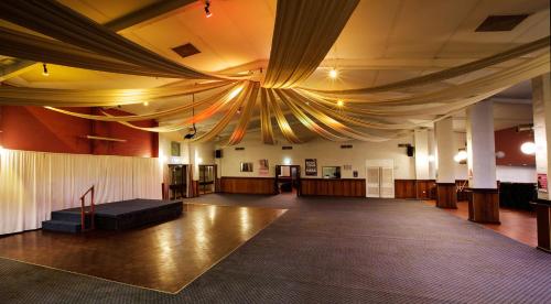 a large room with a ceiling with a stage at Nightcap at Wintersun Hotel in Geraldton