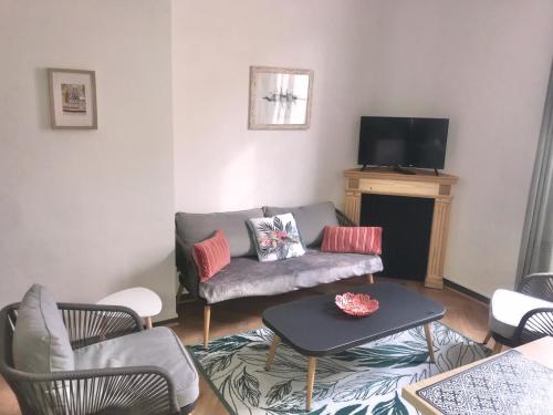 un salon avec un canapé, des chaises et une télévision dans l'établissement Appartement Cosy et Calme - Centre historique, à Montpellier
