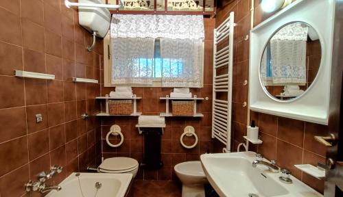 a bathroom with a toilet and a sink and mirror at Abetina Apartment - Piccola Svizzera in Tagliacozzo