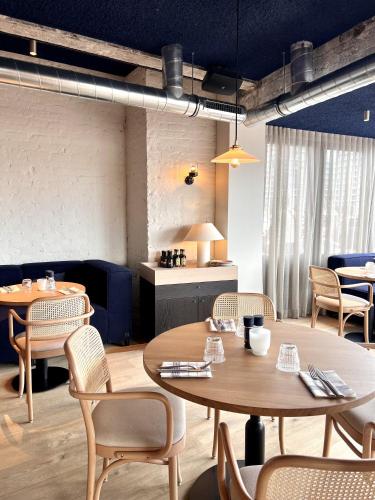 a restaurant with tables and chairs and a kitchen at C-Hotels Burlington in Ostend