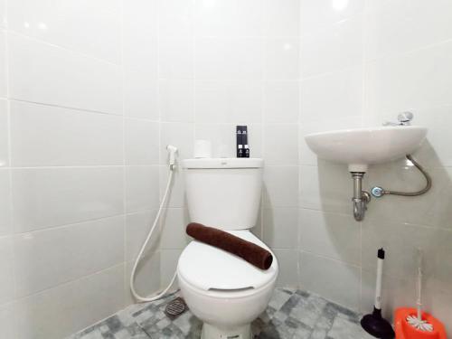 un baño con inodoro y lavabo en Modern Look and Homey Studio Amartha View Apartment By Travelio, en Semarang