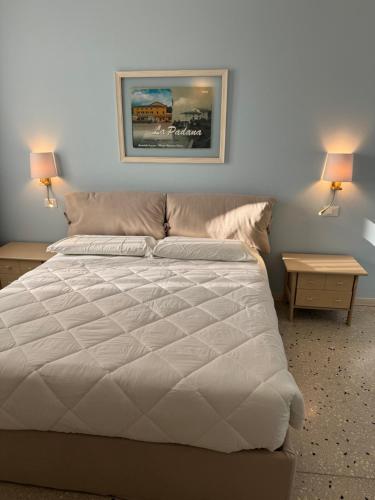 a bedroom with a white bed with two night stands at Albergo La Padana in Montebello Vicentino