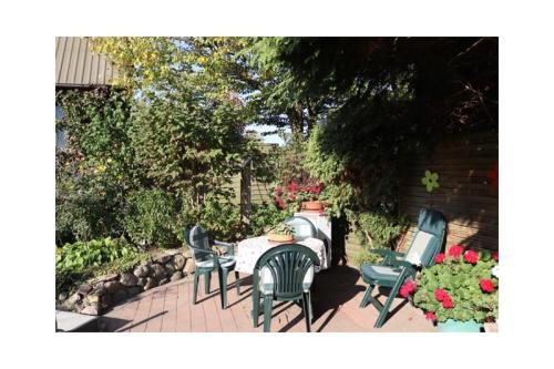 a patio with a table and chairs and flowers at Haus Dreeßen in Buchholz