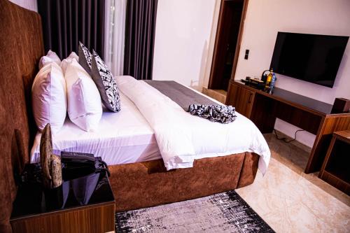 a hotel room with a bed and a television at The Stallion Abuja in Abuja