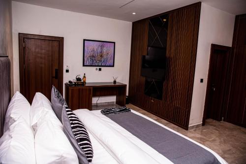 a hotel room with a bed and a television at The Stallion Abuja in Abuja