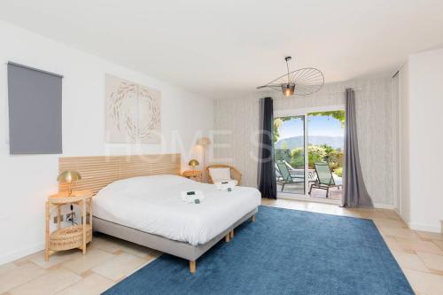 a bedroom with a bed and a blue rug at Villa de vacances 5 chambres piscine privée et vue mer panoramique in Mandelieu-la-Napoule