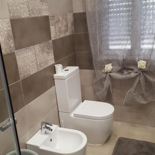 a bathroom with a toilet and a sink at Villa Joel in Fontane Bianche