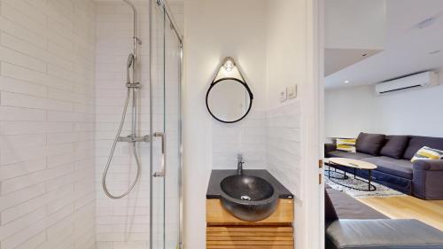 La salle de bains est pourvue d'une douche et d'un bol noir sur une table. dans l'établissement 333 Suite Chou - Superbe Appartement à Paris., à Paris
