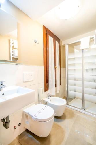 a bathroom with a toilet and a sink and a shower at Hotel Tintoretto in Venice
