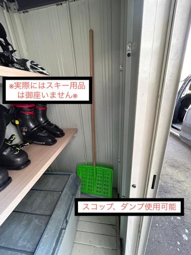 a shelf with a broom and a green basket at Learch Asahikawa in Asahikawa