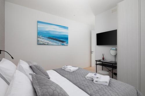 a bedroom with a bed with two towels on it at Villa Piano Turanj - Adriatic Luxury Villas in Turanj