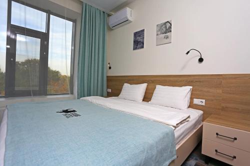a bedroom with a bed and a large window at Scandi Hotel in Uralsk