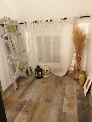 Cette chambre est dotée de rideaux blancs et de parquet. dans l'établissement La Chèvrerie de Saint-Vigor, à Saint-Vigor-dʼYmonville