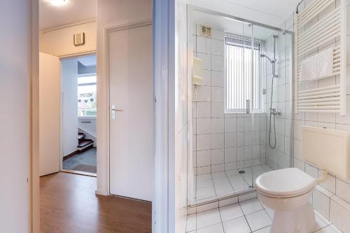 a bathroom with a toilet and a shower at Hello Zeeland - Apartment Noordstraat 30 in Zoutelande
