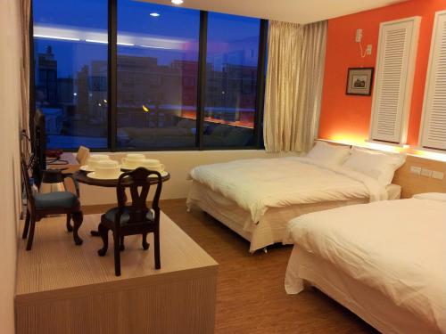 馬公市的住宿－哈利路亞民宿，酒店客房设有两张床、一张桌子和一个窗户。
