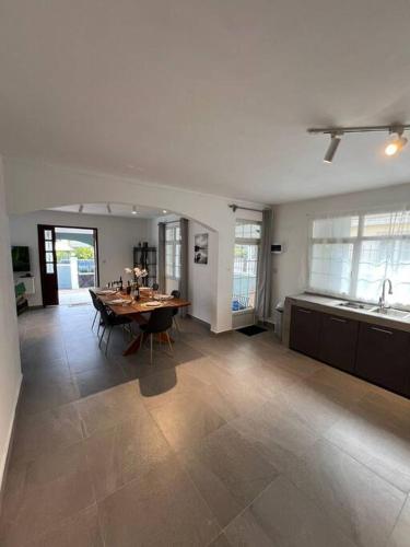 a living room with a table and a kitchen at 3 BR Villa Agape with Pool in Tamarin