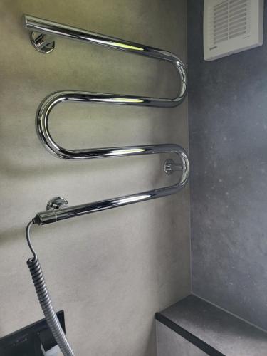 a bathroom with a shower head and a hose at Bigge Elements Tinyhaus 5 "Wasser" in Olpe