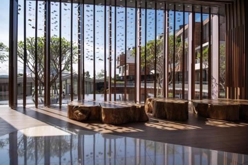a lobby with wooden logs in front of a large window at WM Hotel Hong Kong, Vignette Collection in Hong Kong