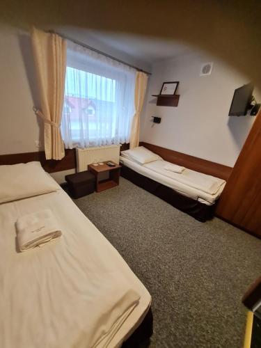 a hotel room with two beds and a window at Przystań Wodna Brody in Styków
