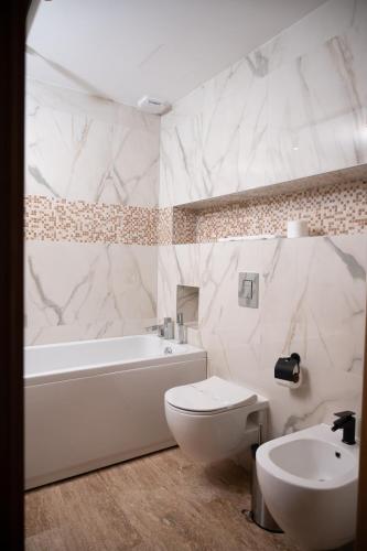 a bathroom with a tub and a toilet and a sink at Hotel Borovi Forest Resort & Spa in Sjenica