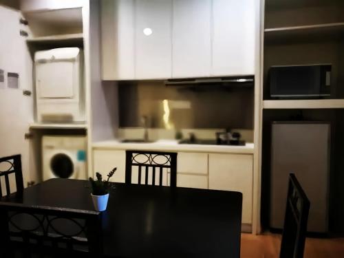 a kitchen with a black table and chairs in a room at 118 Island Plaza Penang in Tanjong Tokong