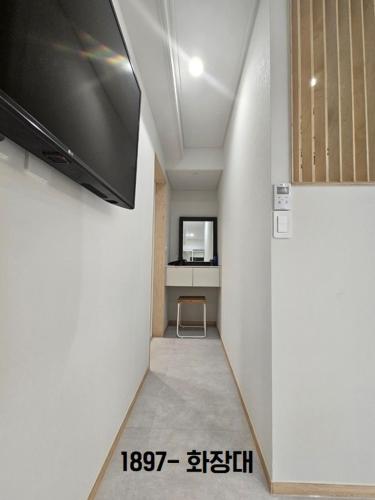 a hallway with a flat screen tv and a desk at Yachtie Inn 1897 in Mokpo