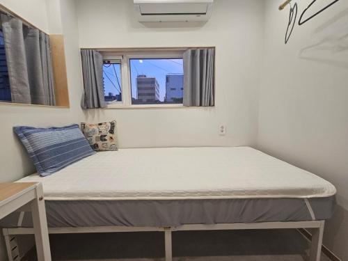 a bed in a room with a window at Yachtie Inn 1897 in Mokpo