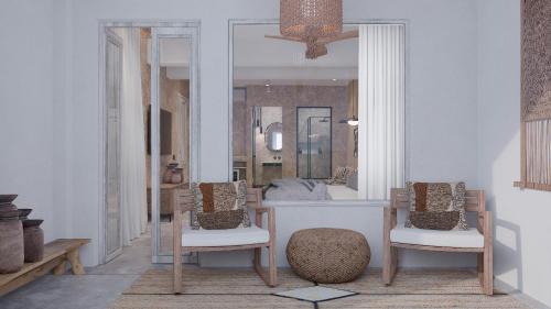 a living room with two chairs and a mirror at F Fine Suites - Adults Only in Líndos