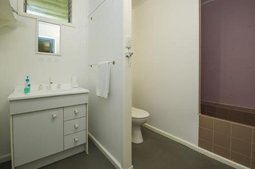 a white bathroom with a sink and a toilet at OurBonnieDoon in Arcadia