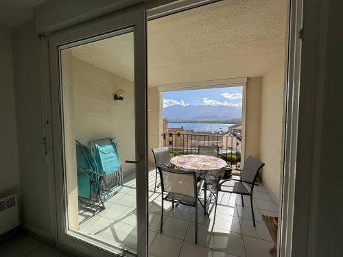 un balcon avec une table et des chaises et une vue sur l'océan dans l'établissement STUDIO BIS Santa Reg, à Calvi