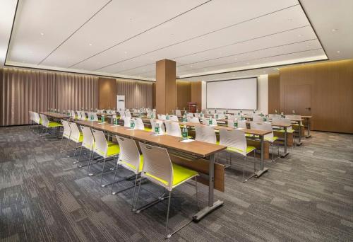 a conference room with tables and chairs and a whiteboard at Mehood EZZI Hotel Jinzhong Jiexiu Middle Beitan Road Railway Station in Jiexiu