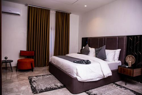a bedroom with a large bed and a large window at The Stallion Abuja in Abuja