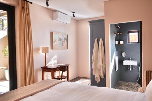 Un dormitorio con una cama y un escritorio en una habitación. en Rose Cottage, en Ciudad del Cabo